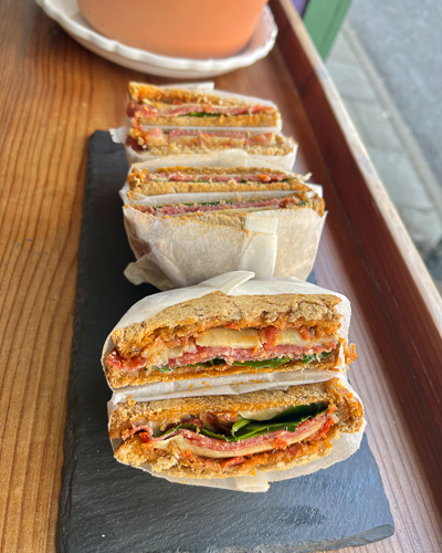 An image showing three sandwiches in the shop front of Emzi, a cafe in Clifton, Bristol